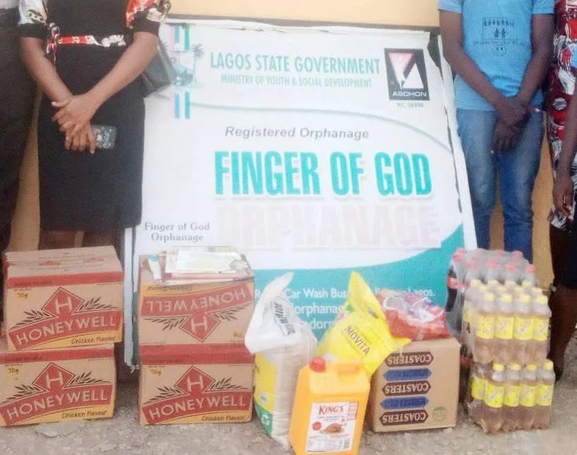 Donated cartons of noodles, cooking oil and drinks in front of a registered orphanage signboard
